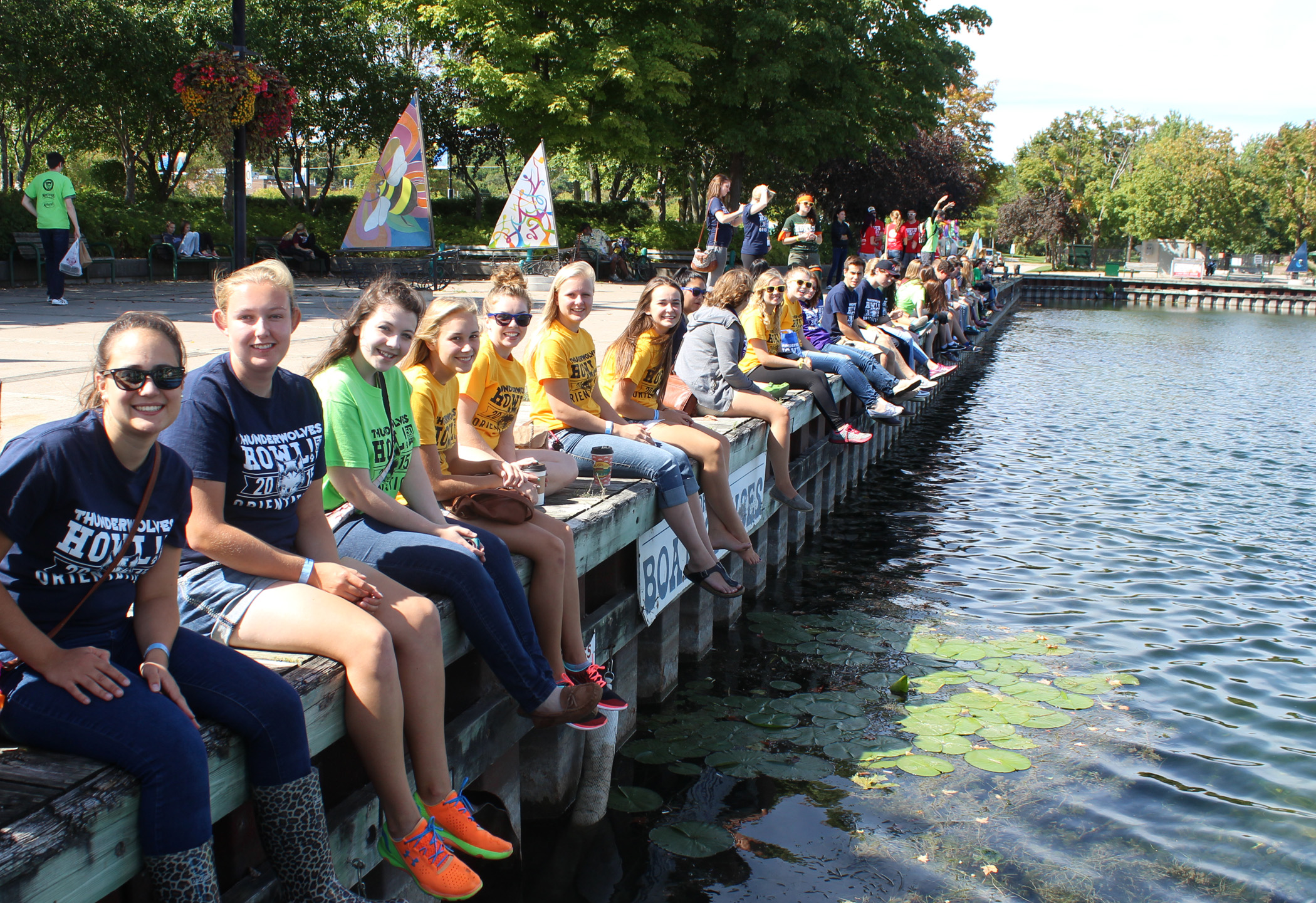 Students in downtown Orillia sitting alongside the waterfront