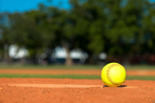 a softball sitting on an empty softball pitch