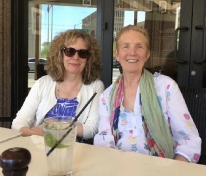 Brenda Chapman, wearing sunglasses, and British crime writer Ann Cleeves sit next to each other a table