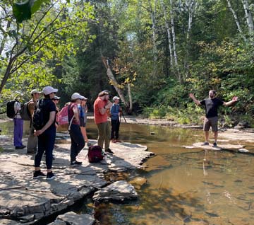 Students learning about the effects of climate change near a river