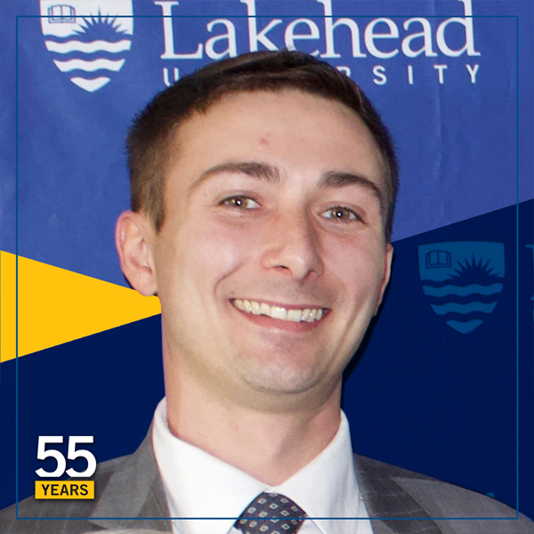 Andrew Petras at a Lakehead University event infront of one of our branded banners
