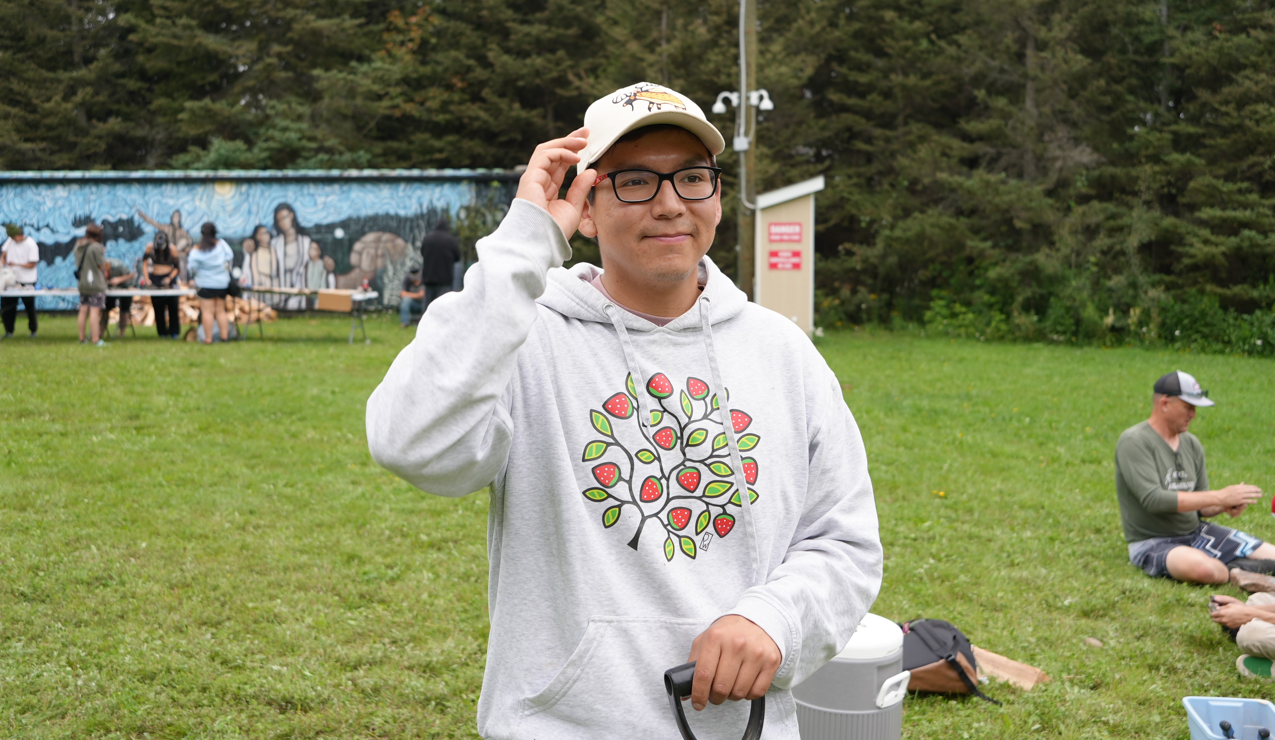 Jared Visitor holds a shovel while assisting with experimental archaeology programming at Lakehead University's Sweat Lodge Site