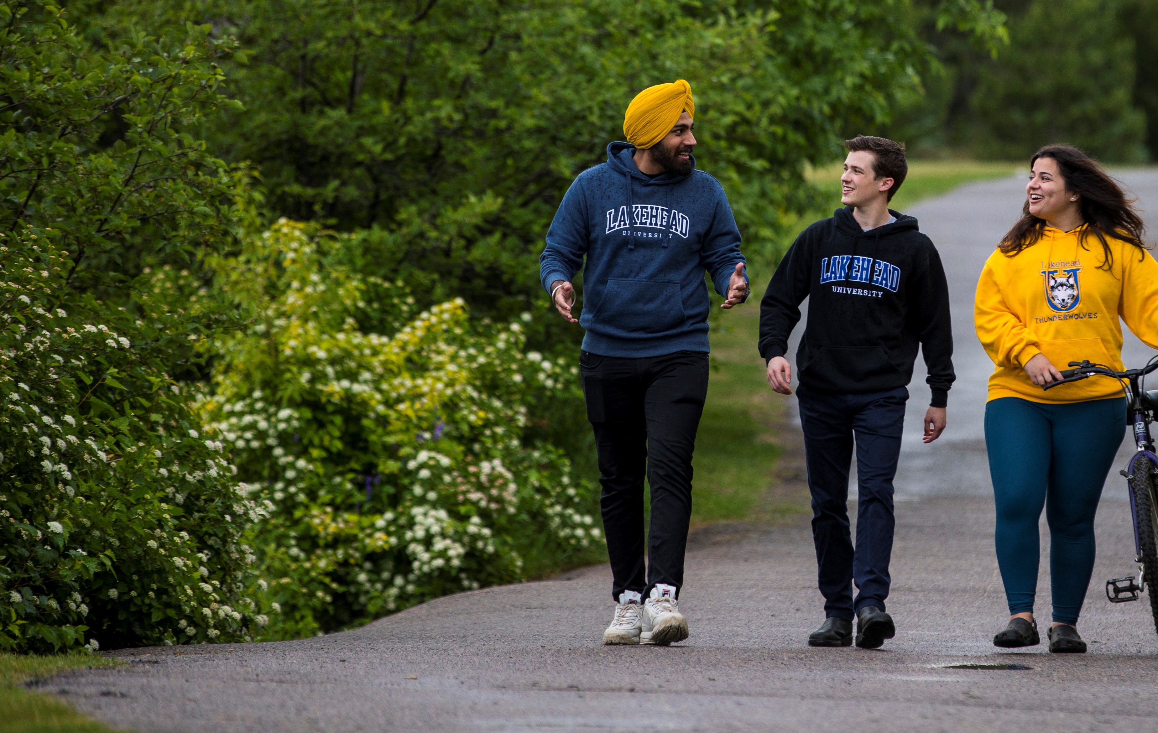 Three Lakehead students walking down a path