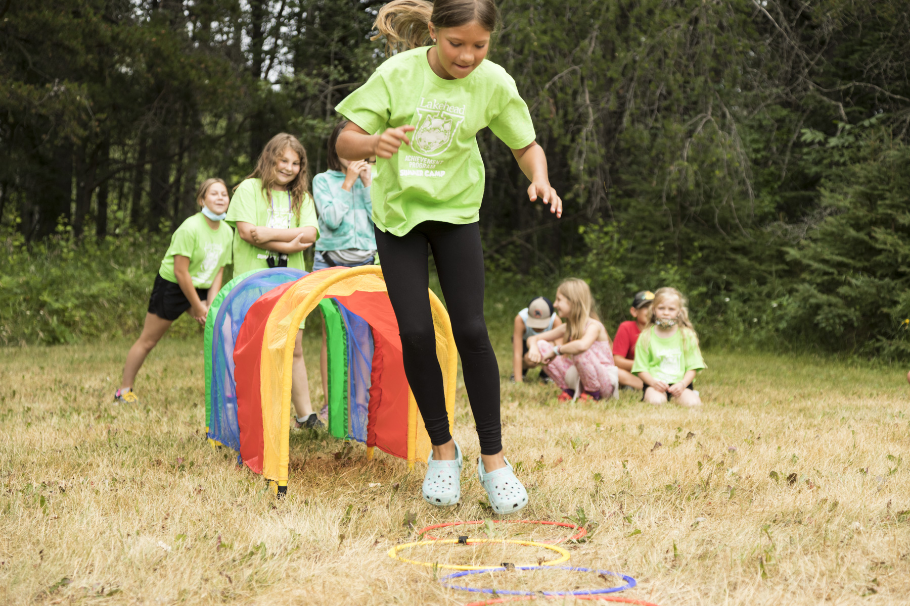 Achievement Program students run through an obstacle course during a 2021 Achievement Program summer camp