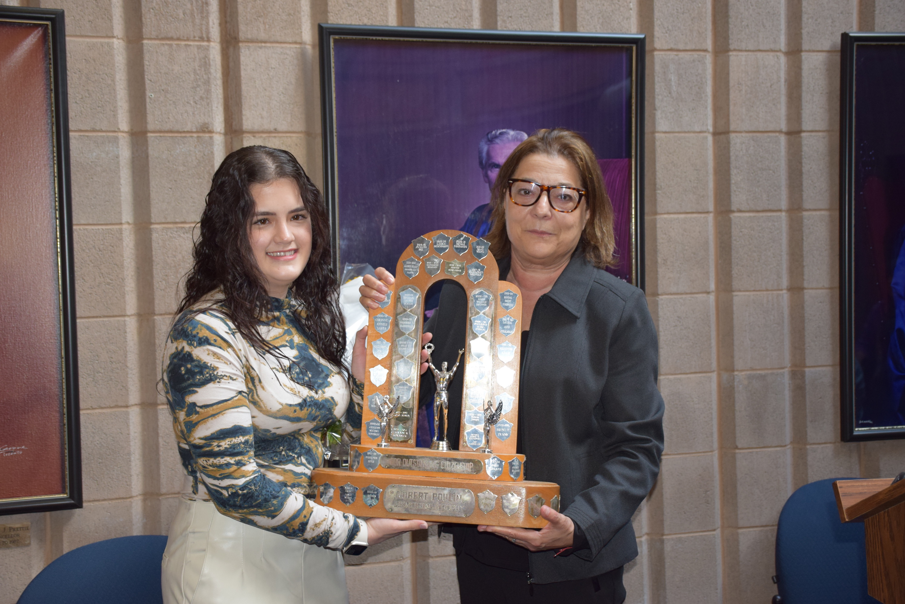 Photo of Marcela Garcia Bueno receiving the Robert Poulin Award trophy from Maria Vasanelli, Chair of Lakehead's Board of Governors.