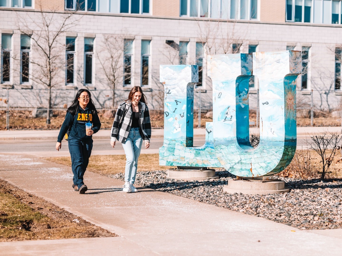 Students walking past the LU sign at the Orillia campus