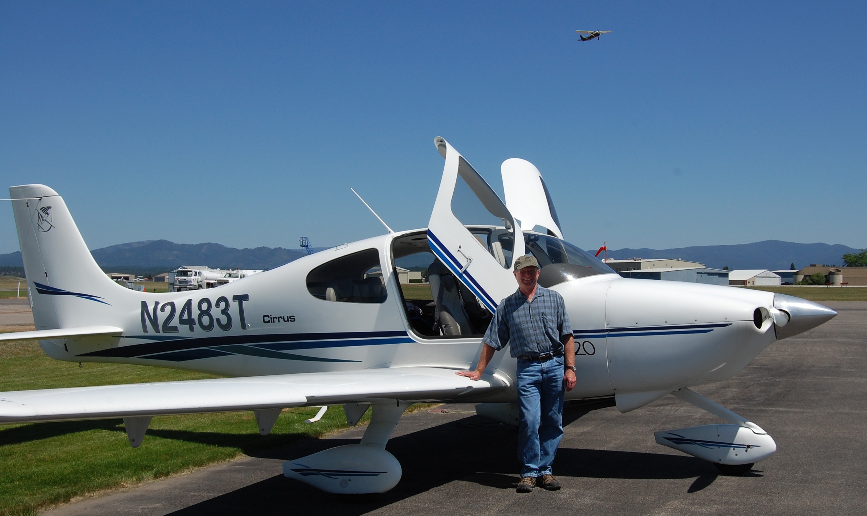 Dick Hembree Beside Plane Dick Hembree stands beside a small prop plane on an airstrip