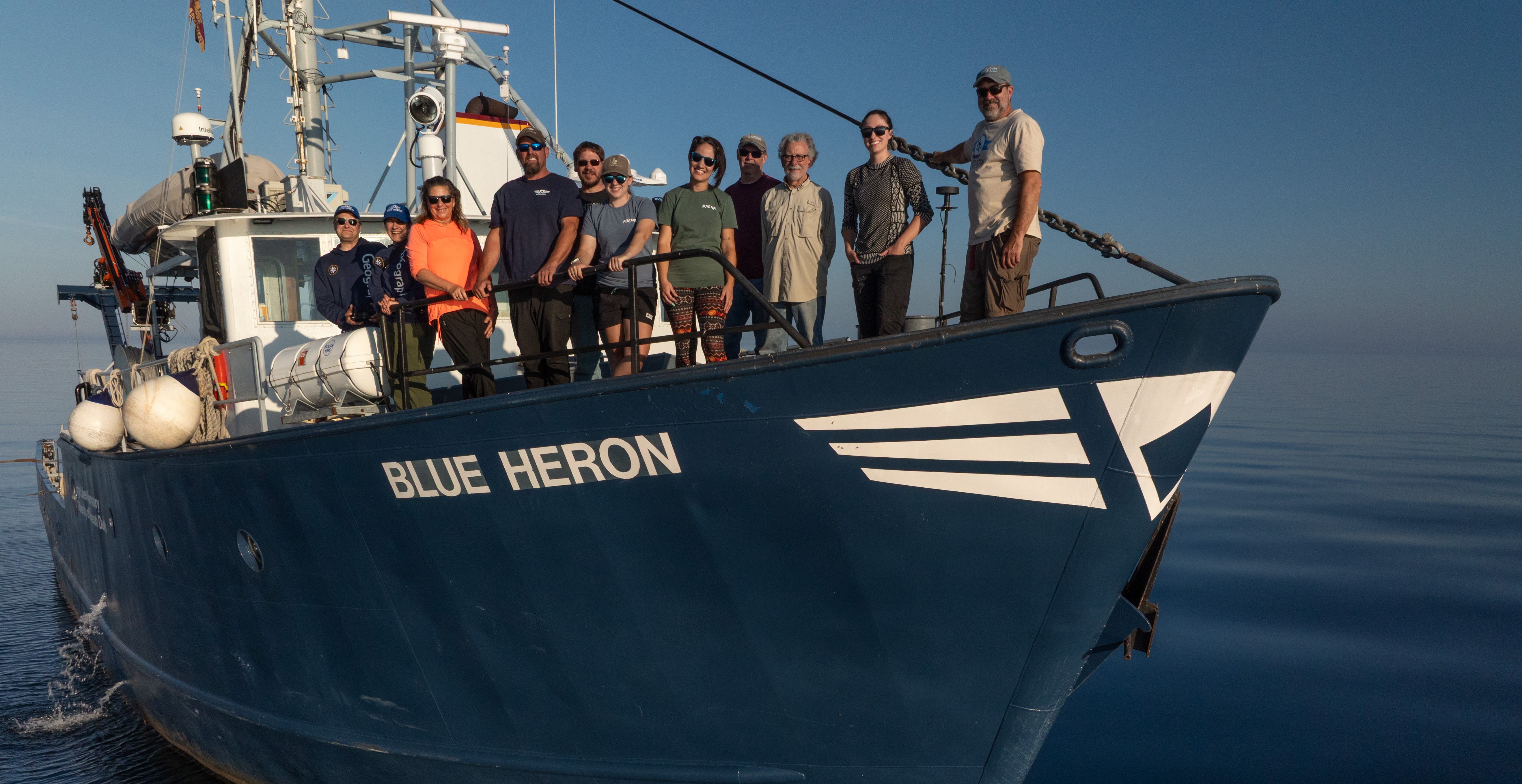 The research crew of the Blue Heron stand on the deck of the ship