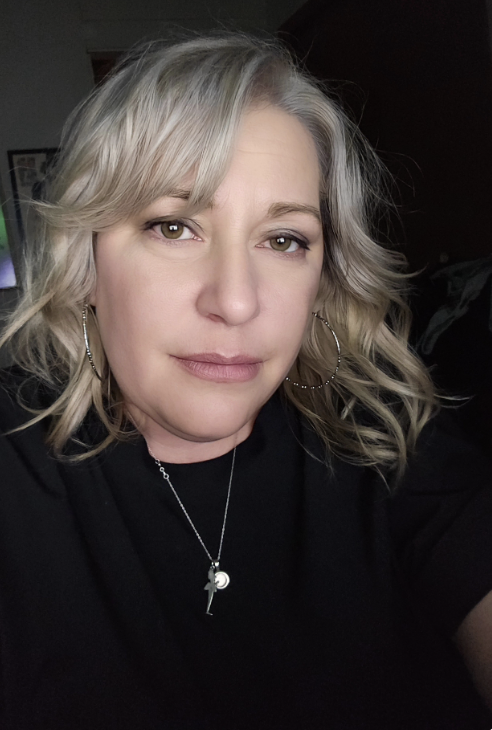 Dr. Dr. Amy Junnila wearing a black shirt and a silver pendant