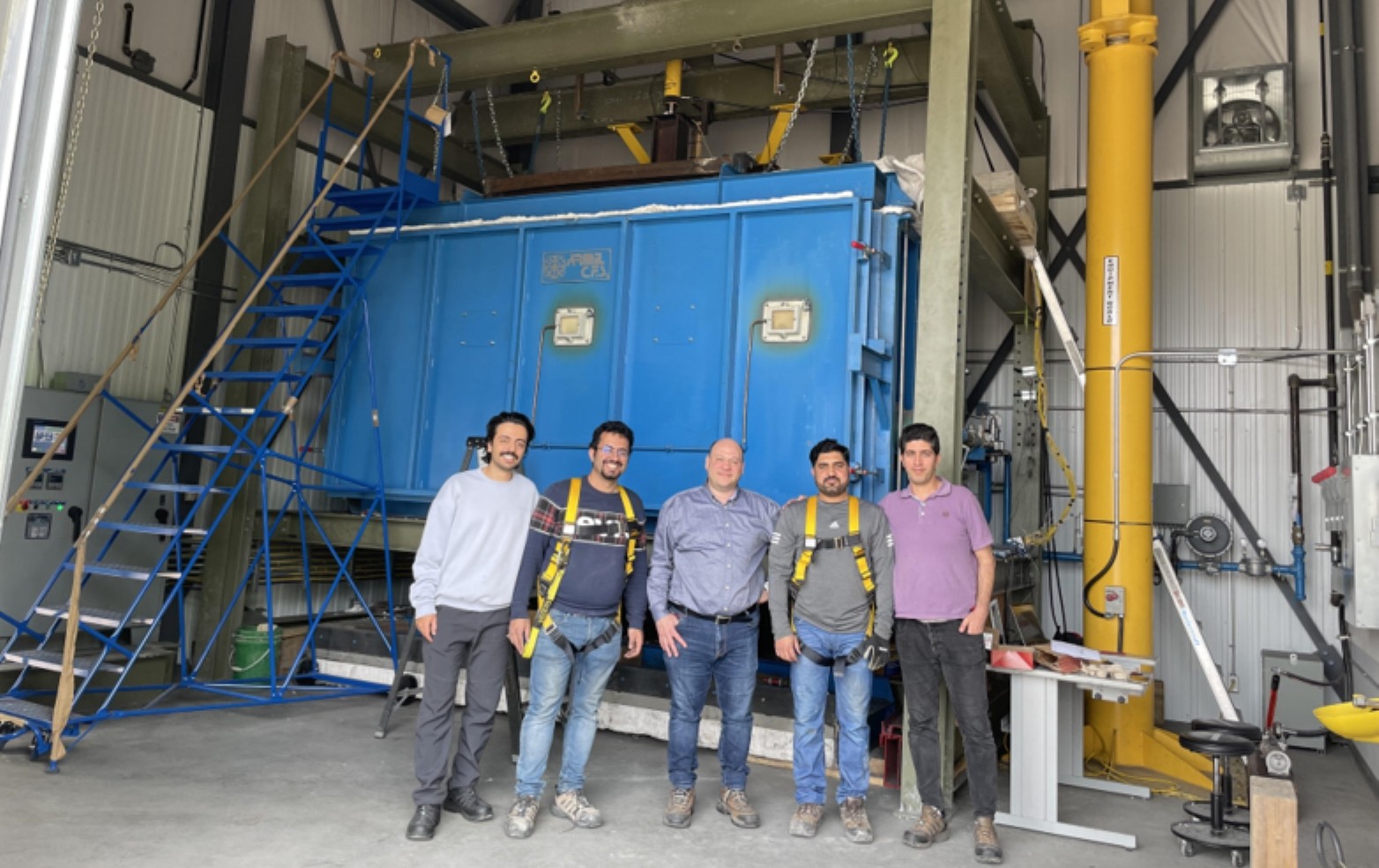 Dr. Sam Salem & Doctoral Students Dr. Sam Salem stands in Lakehead's Structural Fire Testing & Research Laboratory with two of his doctoral students standing on either side of him