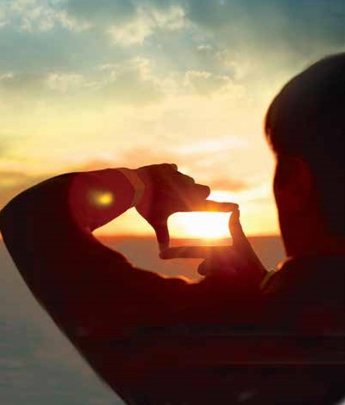 Fingers shaped in a box around a sunset