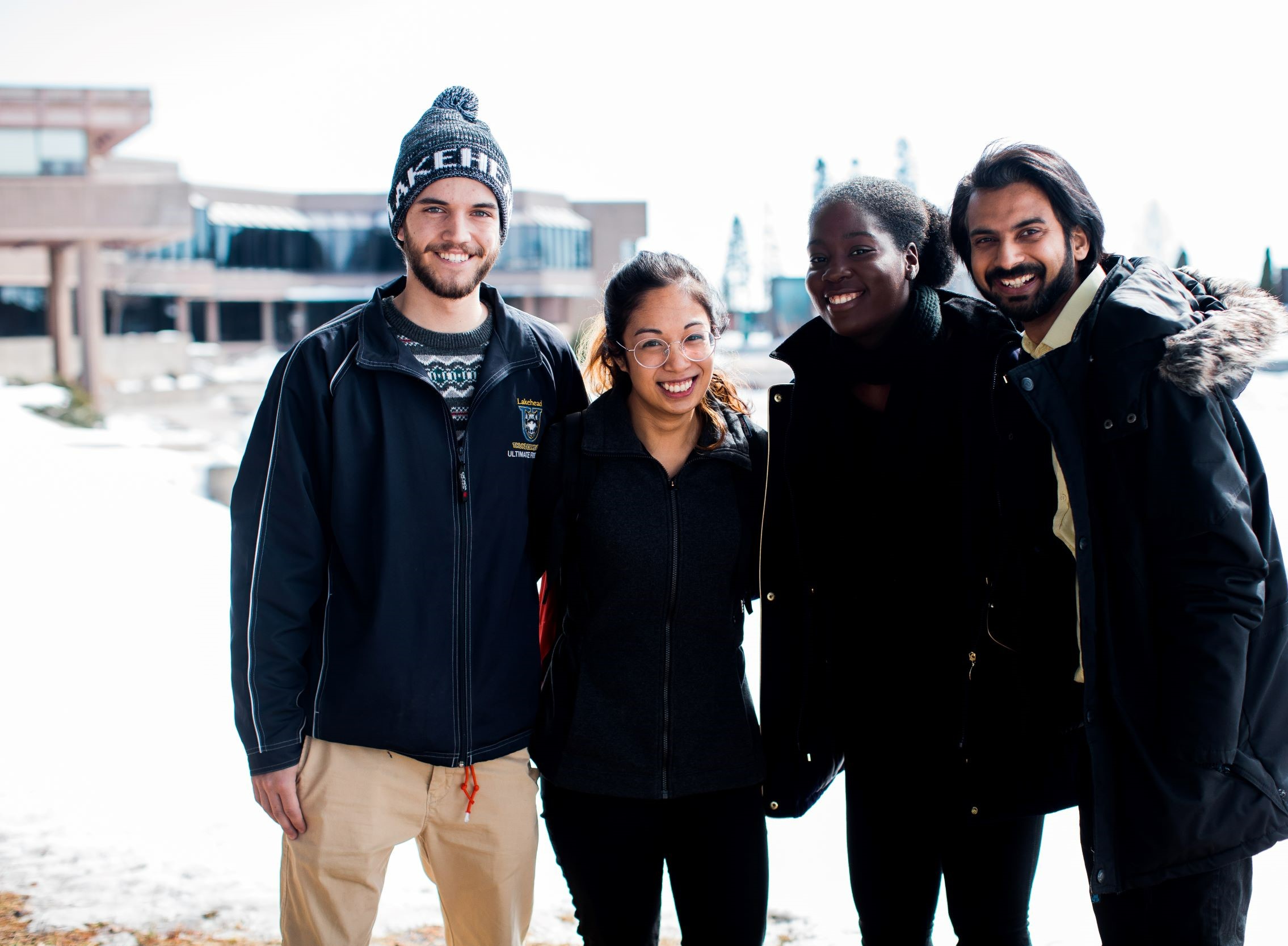 Four Lakehead students on Thunder Bay campus in the winter