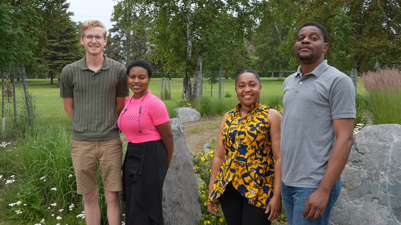 Four Lakehead Philosophy of Education students stand at the entrance of the Wellness Path labyrinth