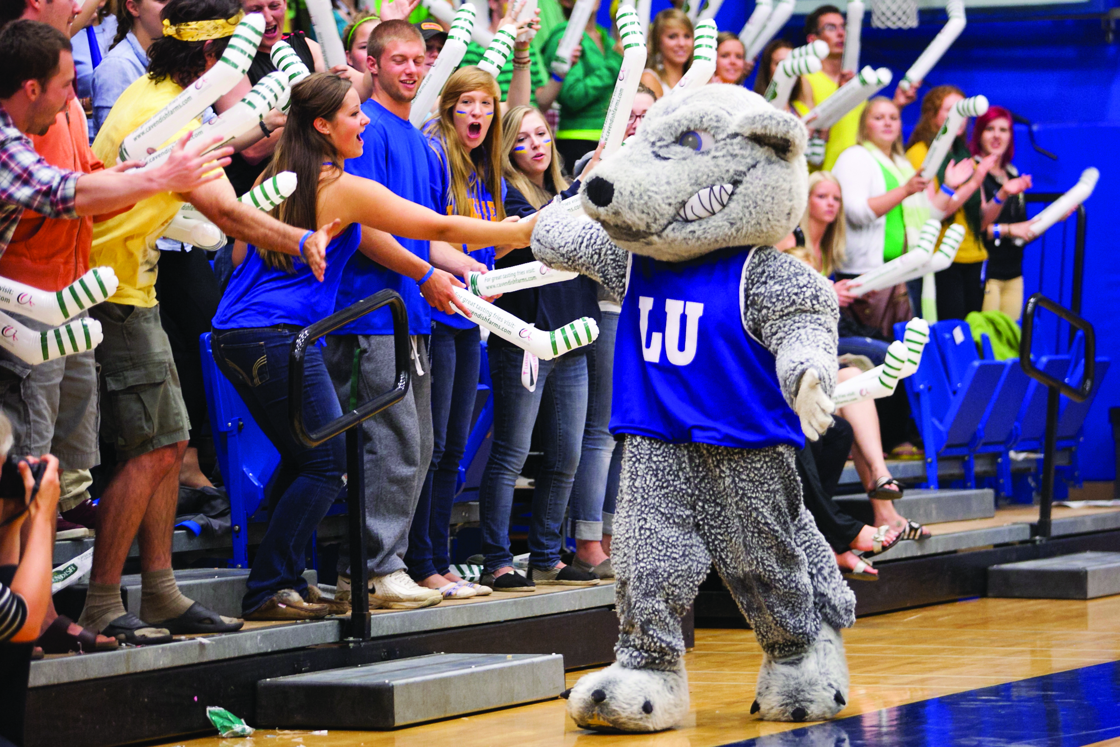 Lakehead's Mascot, Wolfie, cheering with a crowd of students during an Orientation event