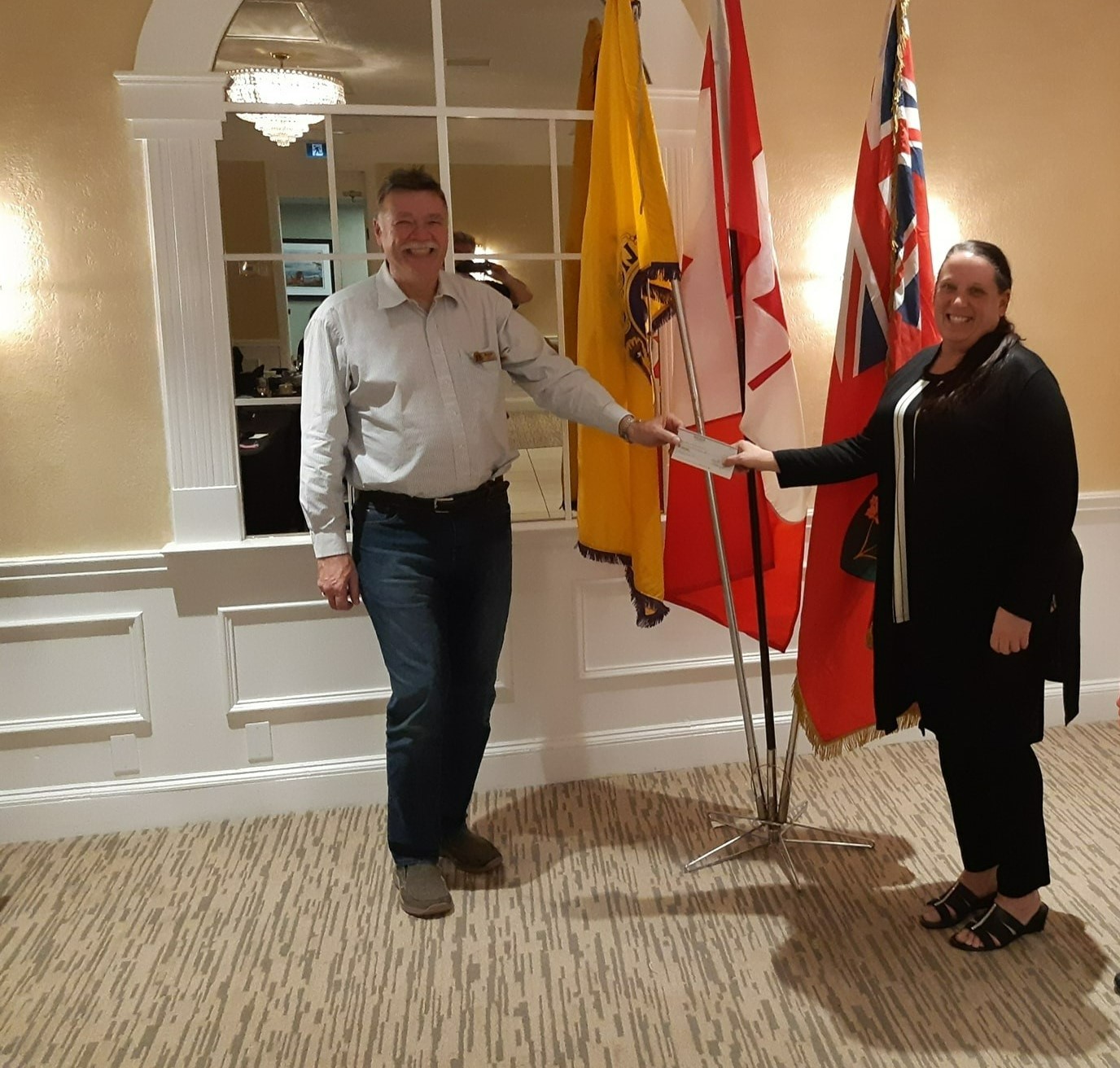 Orillia Lions Club President Mike Taylor presents a cheque to Lakehead staff members