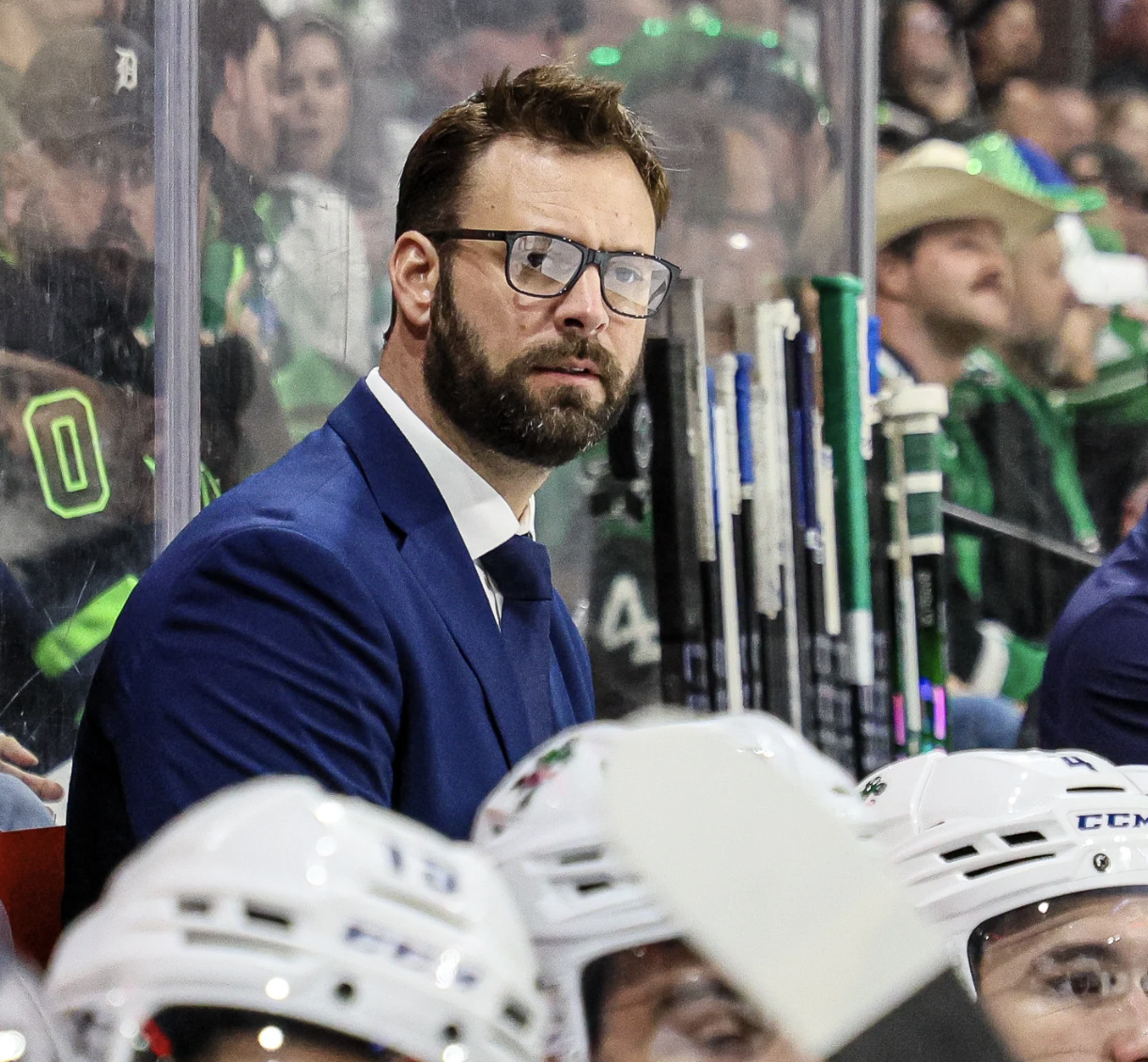 Jordan Smith coaching behind hockey bench
