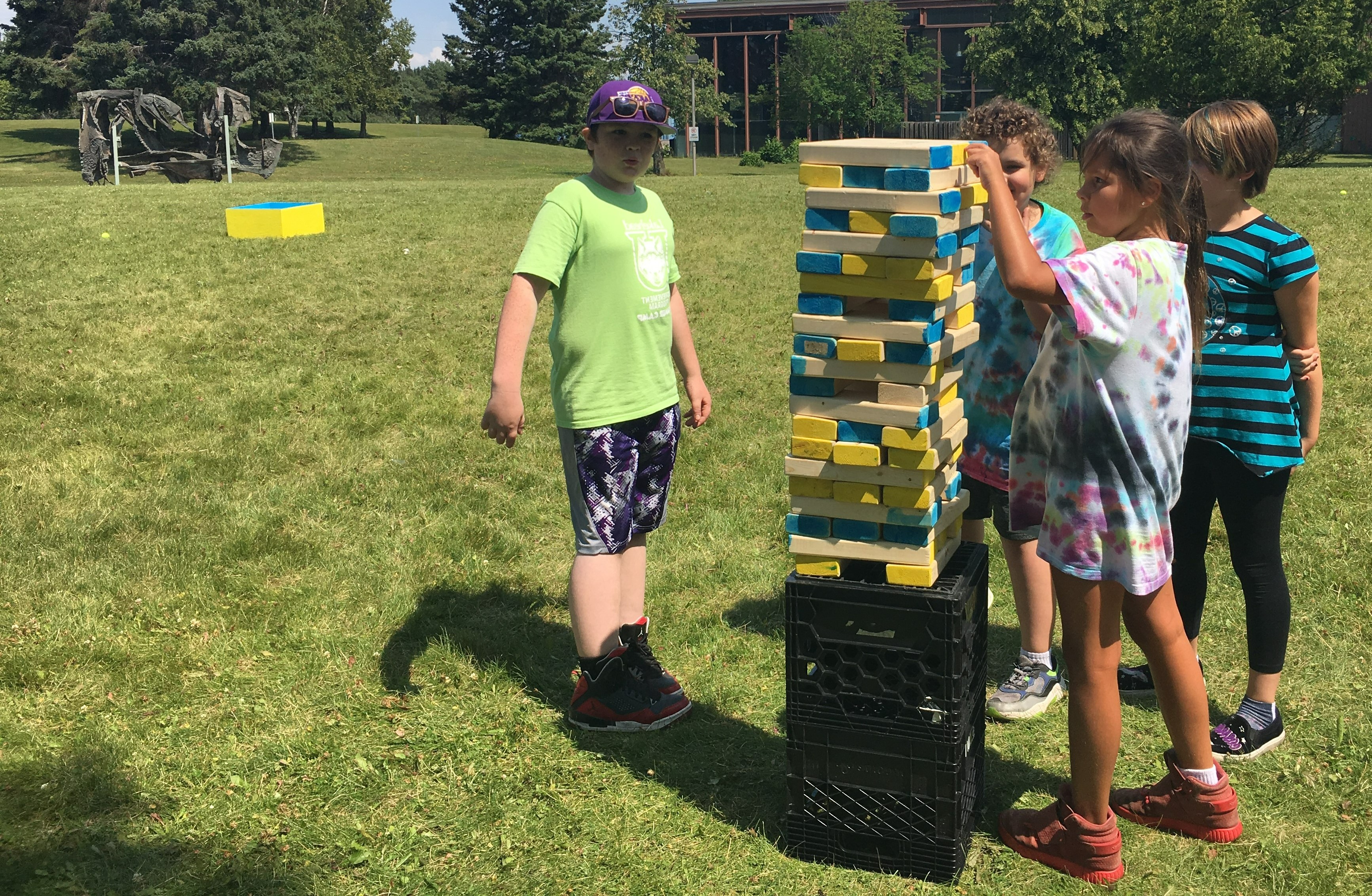 Children Stacking Blocks Children in ActiveU program stacking wooden blocks into a tower on the lawn of the Thunder Bay campus