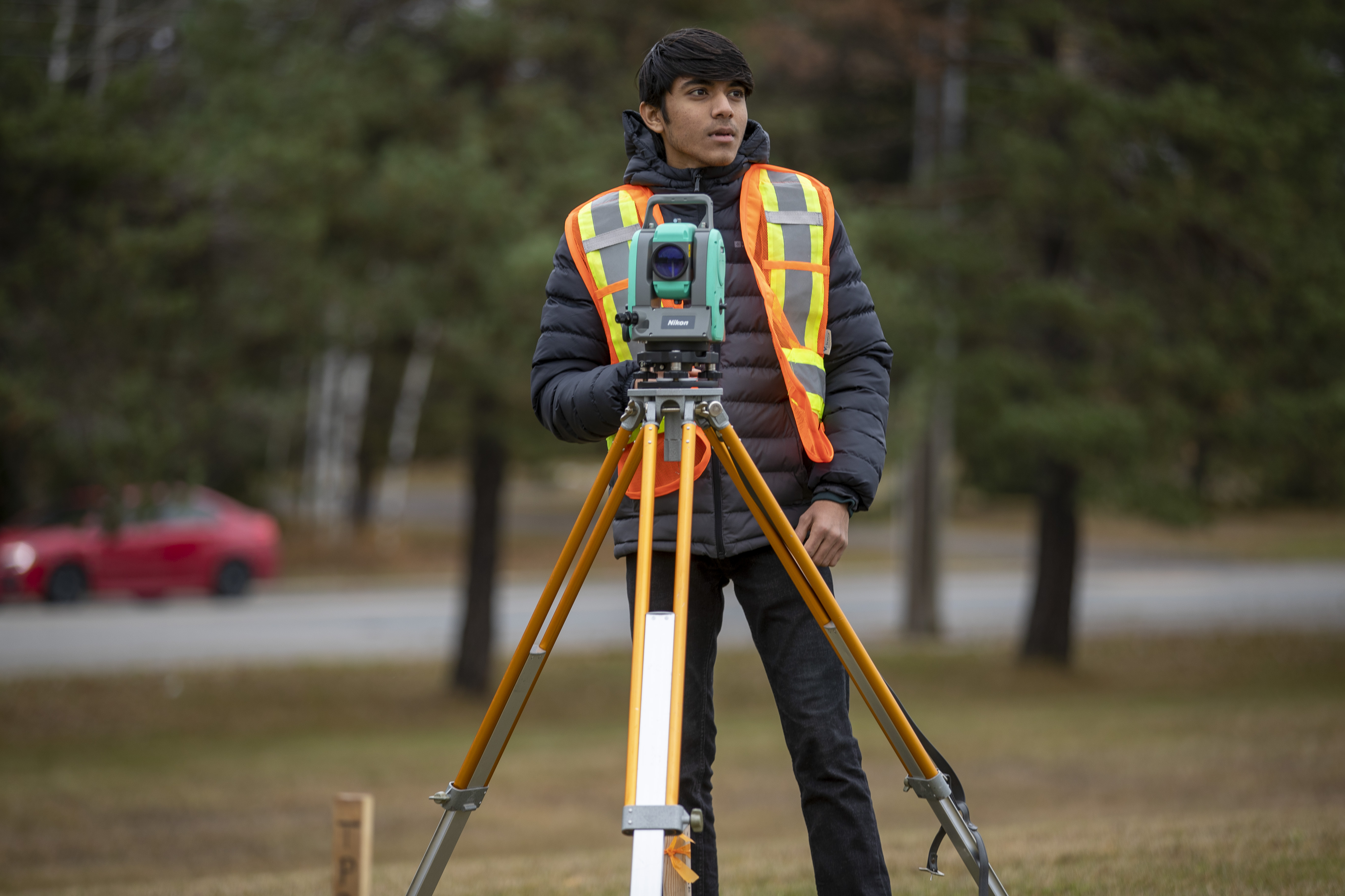 Student on work term with surveying equipment