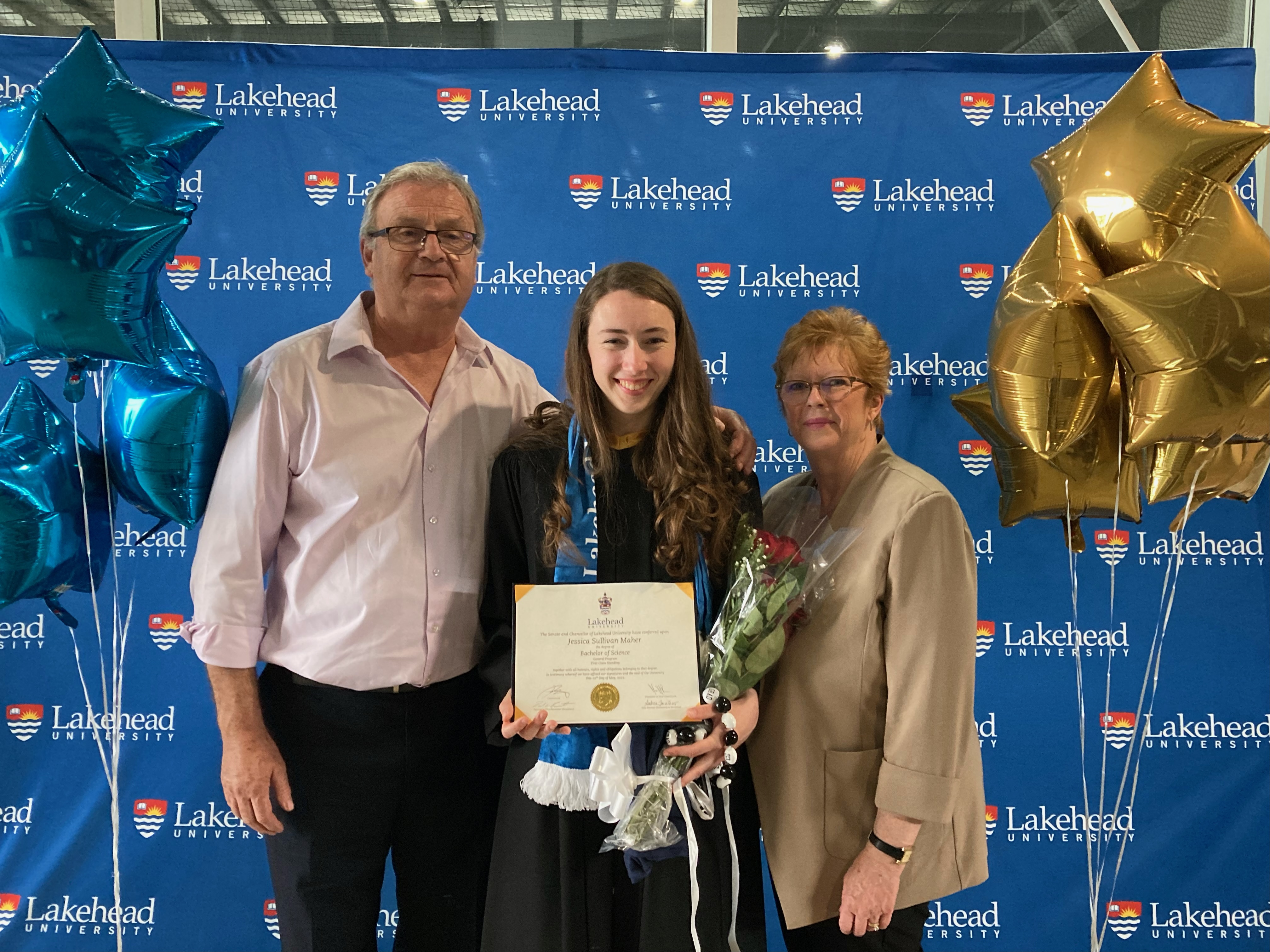Jessica posing with parents after her Lakehead convocation ceremony