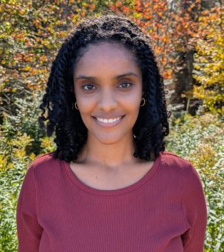 Portrait photo of Muna, a woman in a red shirt
