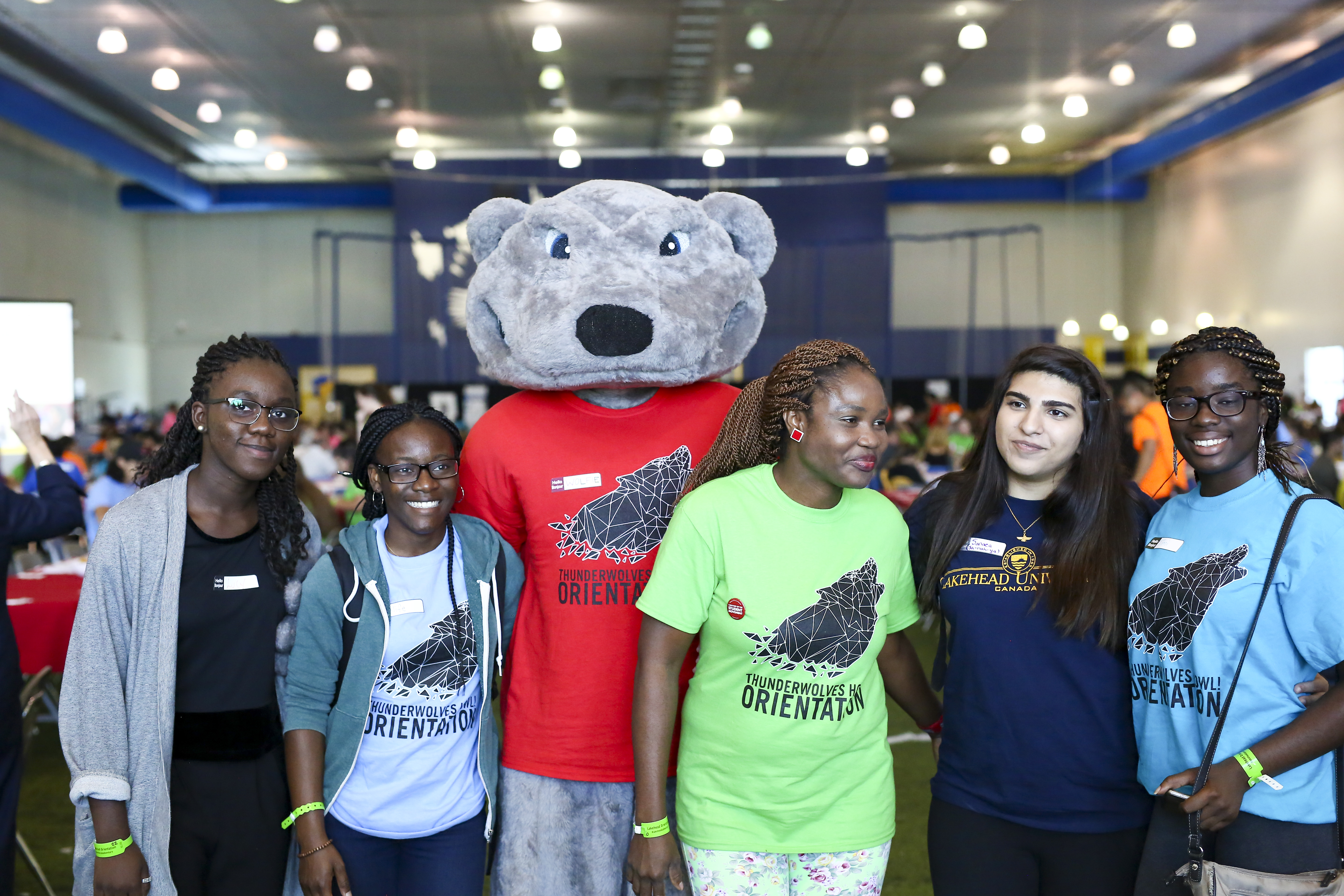 Student posing for a picture with Lakehead mascot, Wolfie.