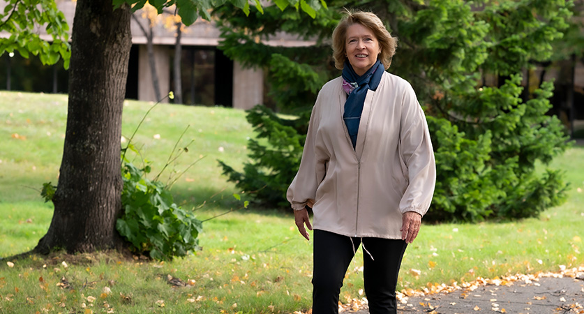 Dr Moira McPherson walks along a path on the Thunder Bay campus