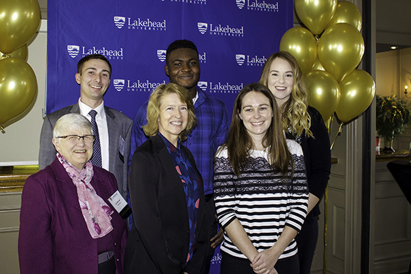 Lakehead University Chancellor Lyn McLeod and President and Vice-Chancellor Dr. Moira McPherson are pictured with alumnus Andrew Petras, current student Bolu Fabanwo, criminology program coordinator and professor Dr. Alana Saulnier, and third year criminology student and event emcee Courtney Holmes.