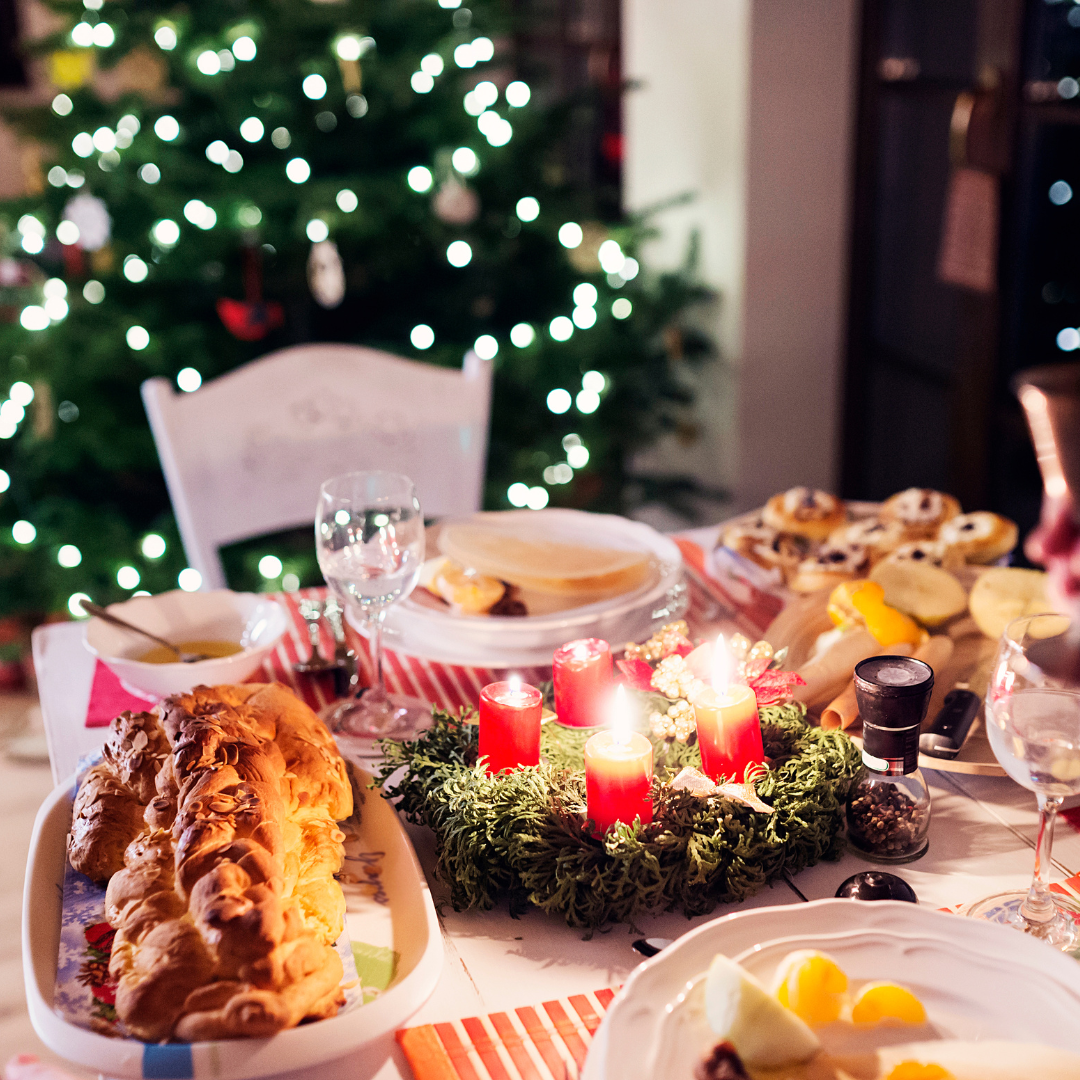 Table of food in front of a out of focus christmas tree