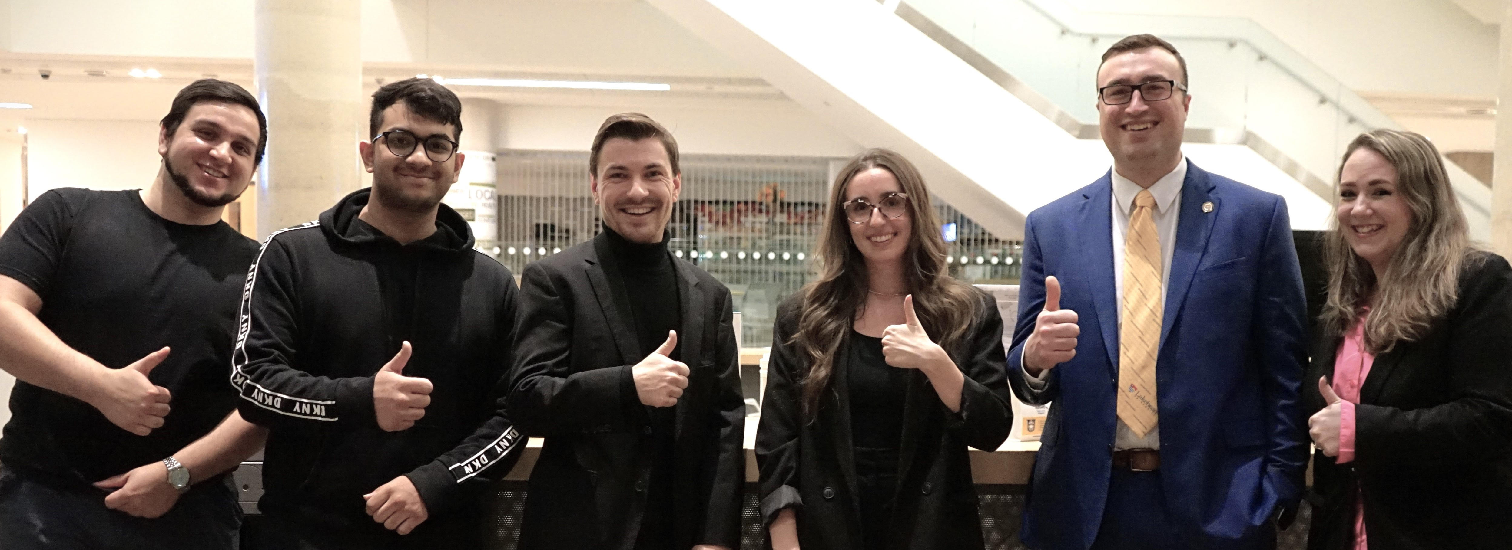Business Orillia Students Society members give thumbs up after event on campus