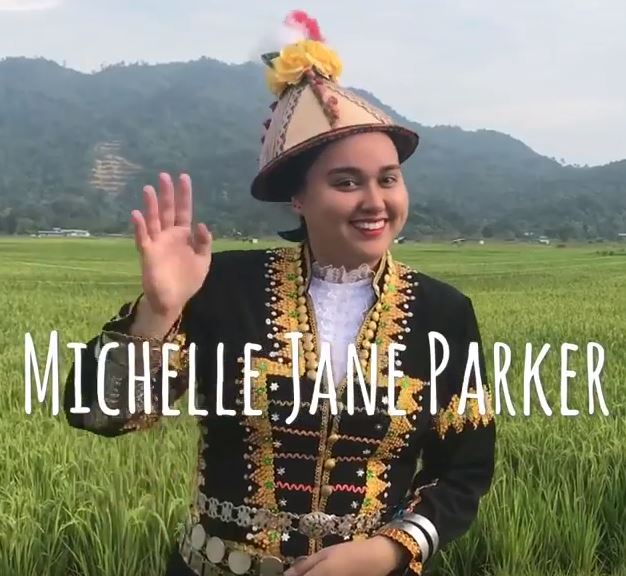 Michelle Jane Parker wearing traditional garb standing in a field smiling for the camera