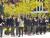 This is a group picture of Maple Leaf students in their uniforms. The group is standing outside in front of a statue