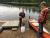 Two students at the shore of a lake doing sampling.  Female student is holding a net. Male student is standing beside a canoea net 