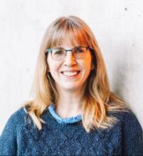 Donna Garstin headshot, with glasses and a blue sweater.