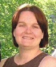 Portrait of Debbie in front of green trees