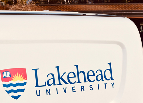 The Lakehead University logo on the side of a van