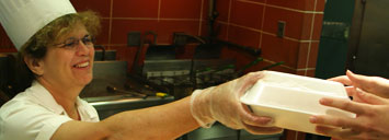 Cafeteria worker handing lunch to student