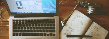 Order your photo ID card online Laptop with an open notebook next to it