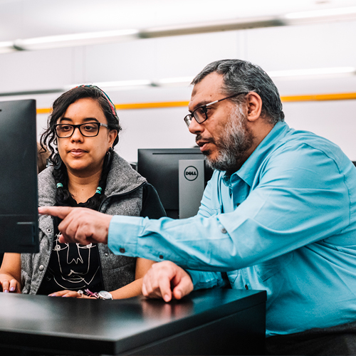 A prof helping a student in a lab