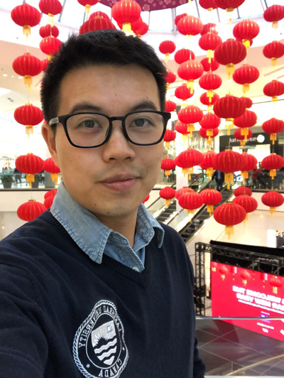 Michael Chen taking a selfie with some festivities in the background