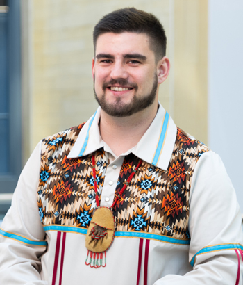 Photo of Tristan Brown in traditional garments smiling