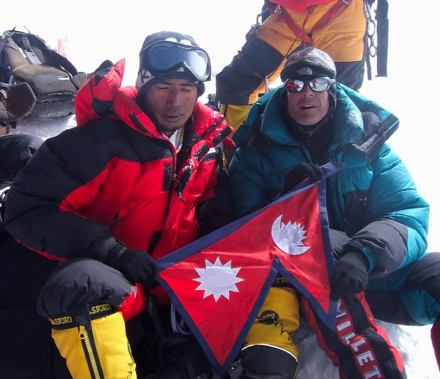 Scott rests at the summit with a Sherpa guide who also made the ascent