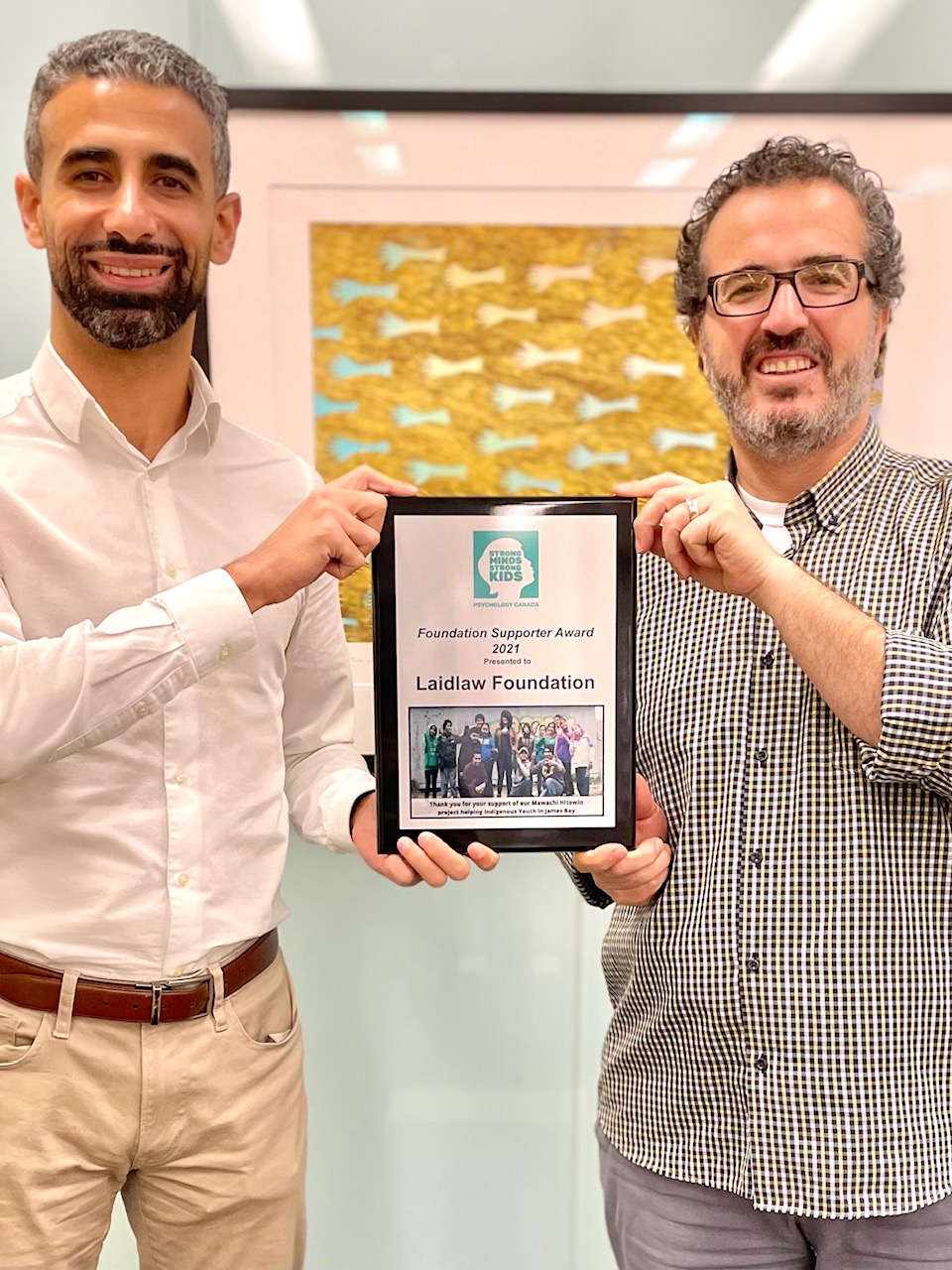 Tamer accepts an Award Tamer (left) and Laidlaw Executive Director Jehad Aliweiwi (right) accept an award from the Psychology Foundation of Canada and Strong Minds Strong Kids.