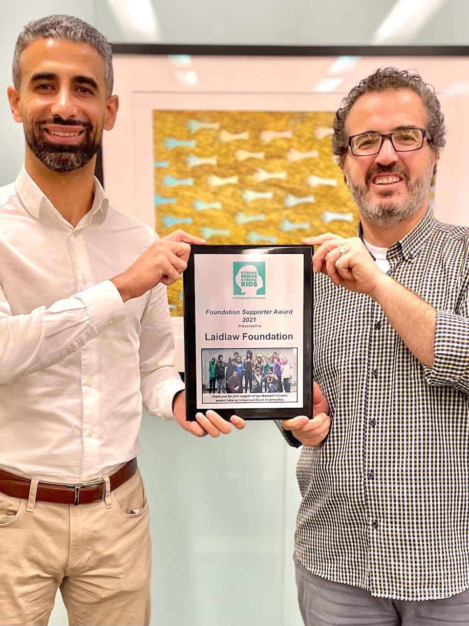 Tamer (left) and Laidlaw Executive Director Jehad Aliweiwi (right) accept an award from the Psychology Foundation of Canada and Strong Minds Strong Kids.