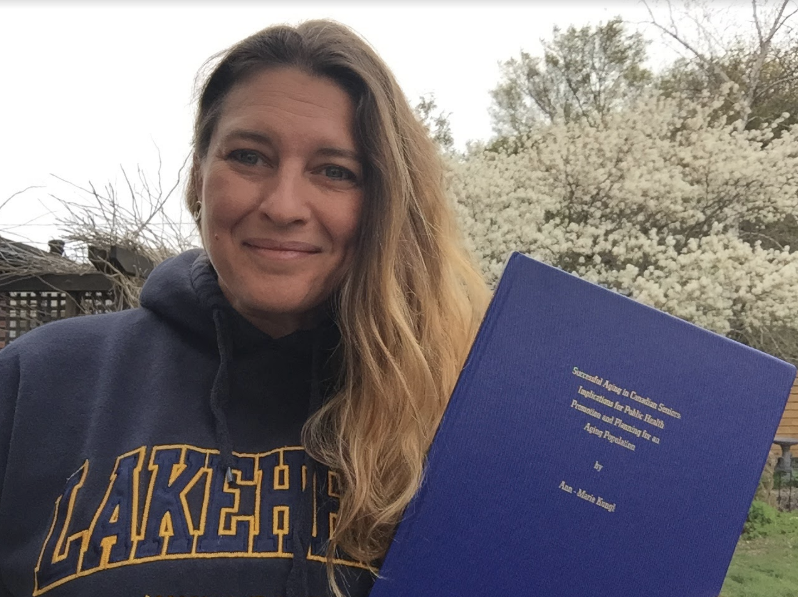 Ann-Marie holds a copy of her Lakehead University master’s thesis.