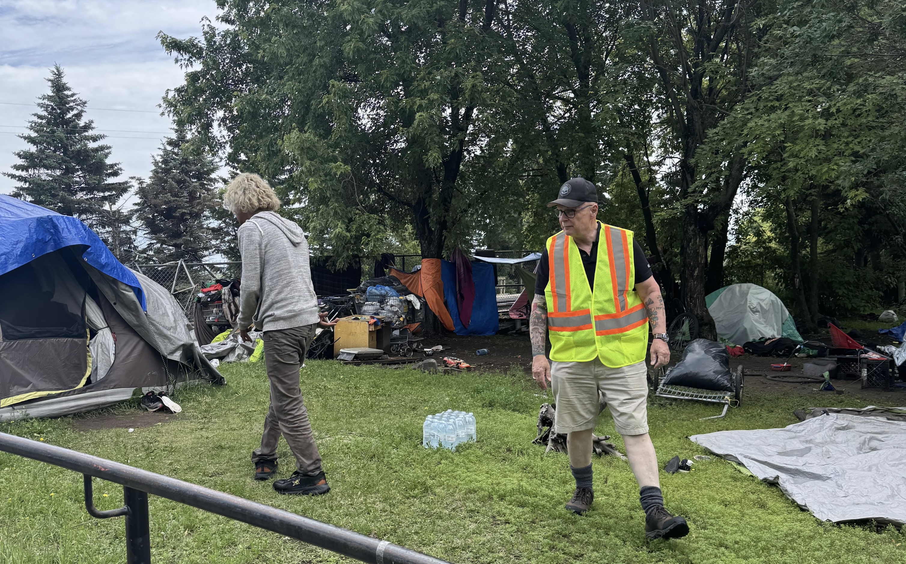 Lorne walking through an encampment