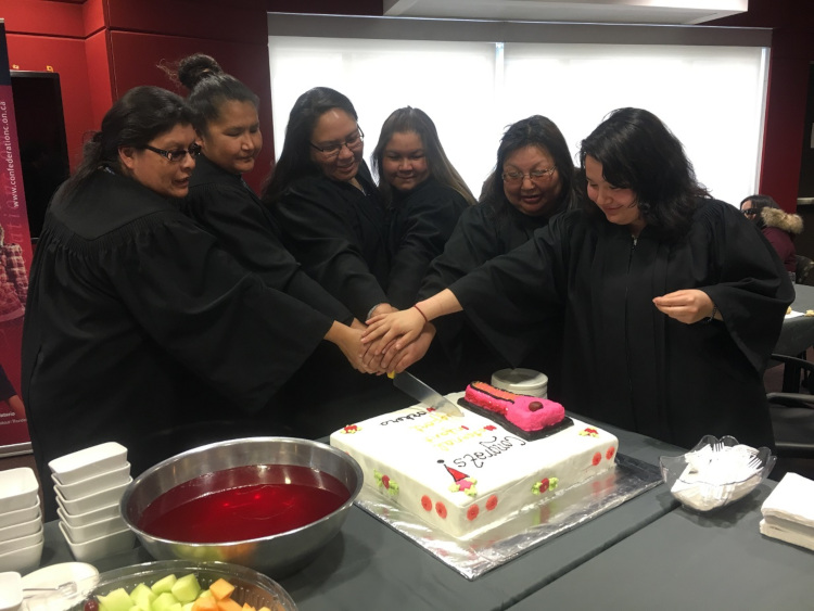Photo of graduates cutting a cake.