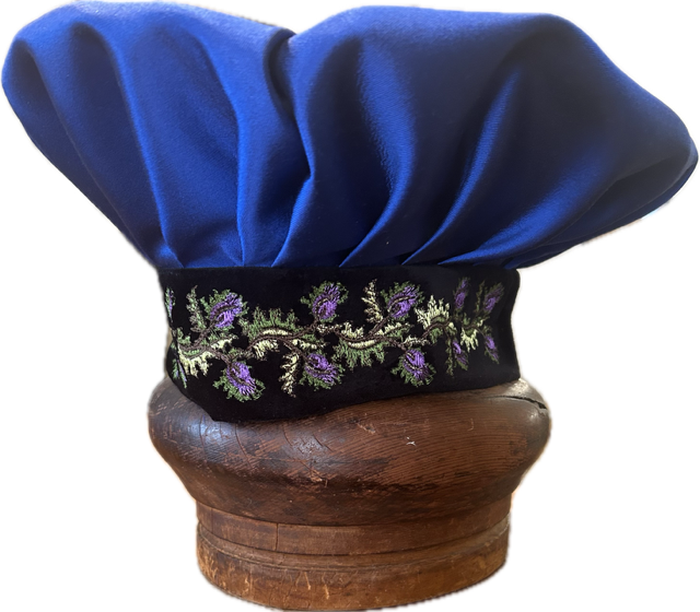 Regalia cap in Lakehead blue with purple, gold and green flowers around the brim