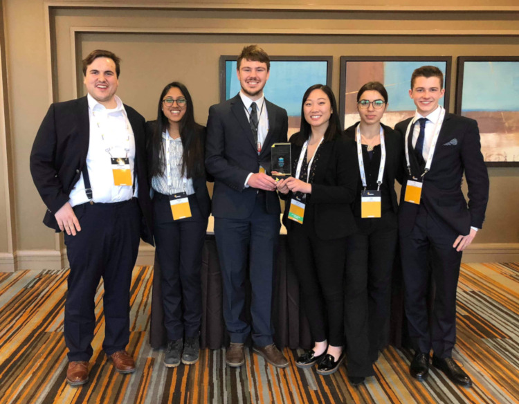 Photo of Enactus team with their trophy.