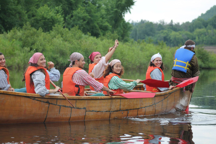 Photo of people in a wooden canoe. 