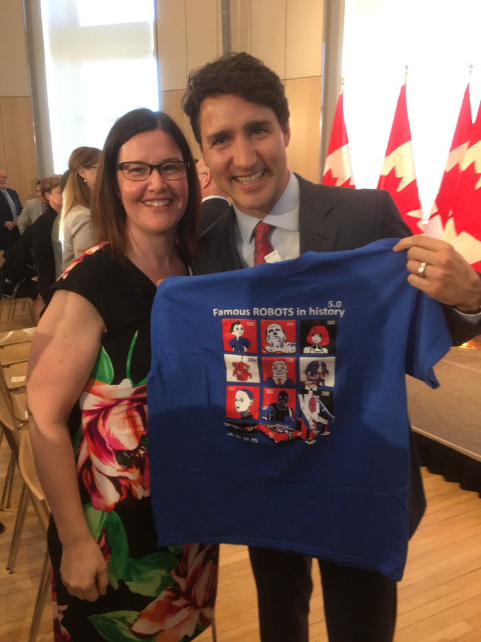 Photo of Kathy Cepo presenting the Prime Minister with the robot team T-shirt.
